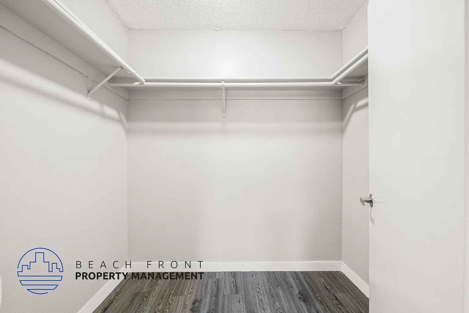 A white room with a logo for Beach Front Property Management.